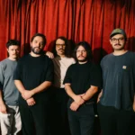 Adiós Cometa con un telón rojo de fondo