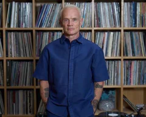Flea con un estante de vinilos detrás