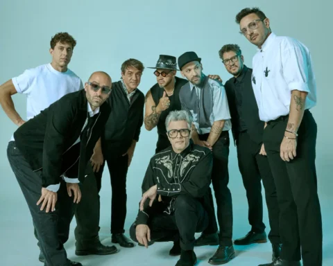 No Te Va Gustar posando en un fondo turquesa