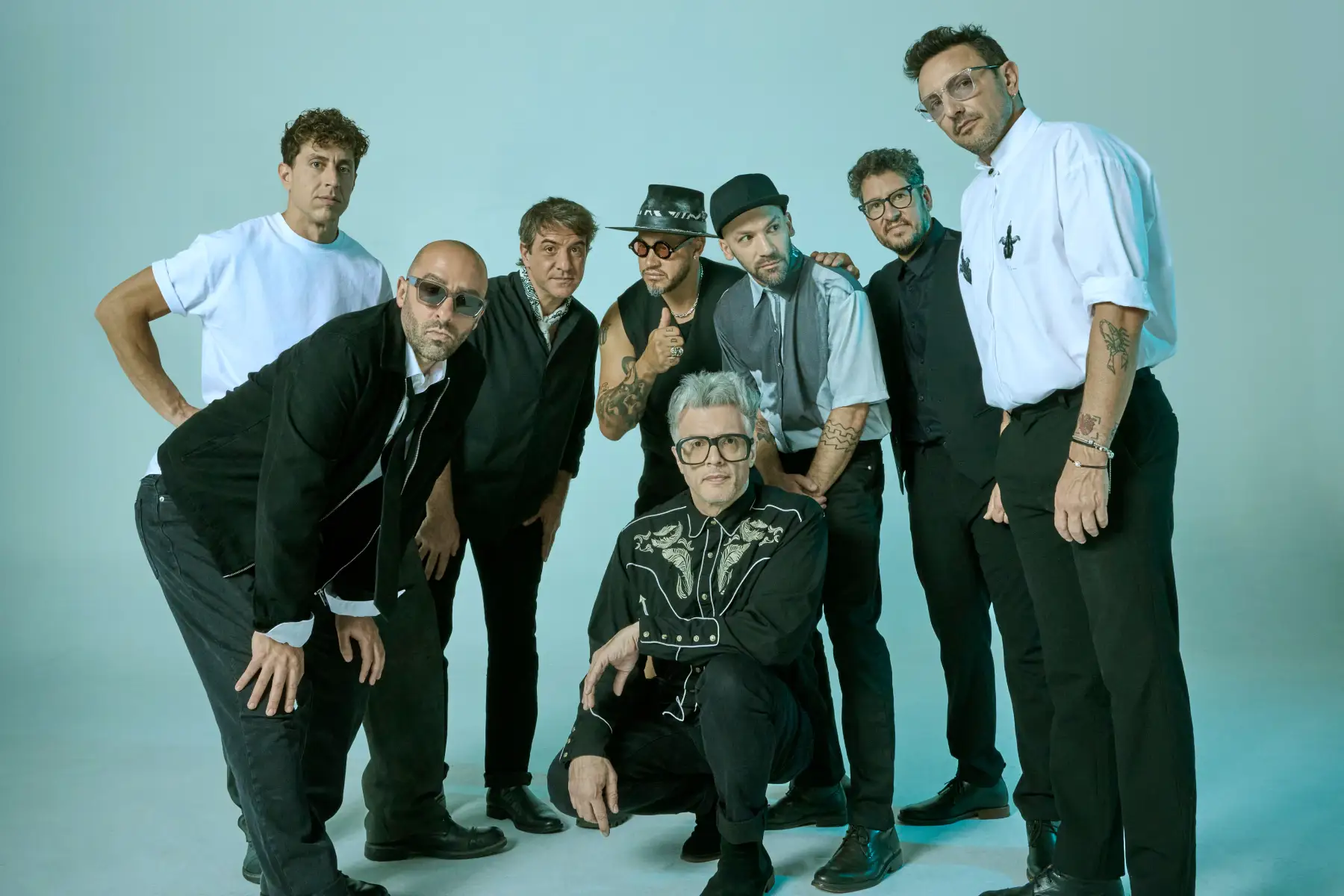 No Te Va Gustar posando en un fondo turquesa