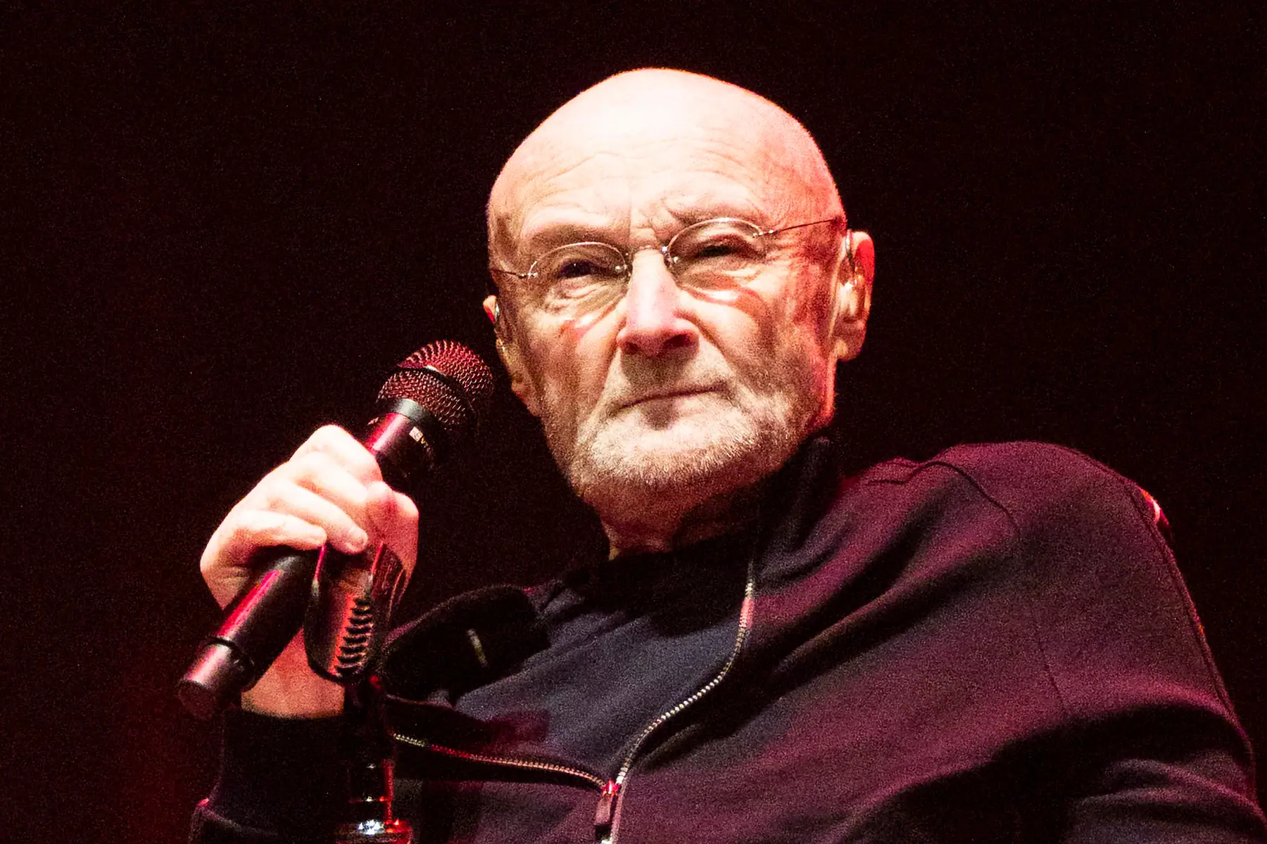 Phil Collins sosteniendo un micrófono
