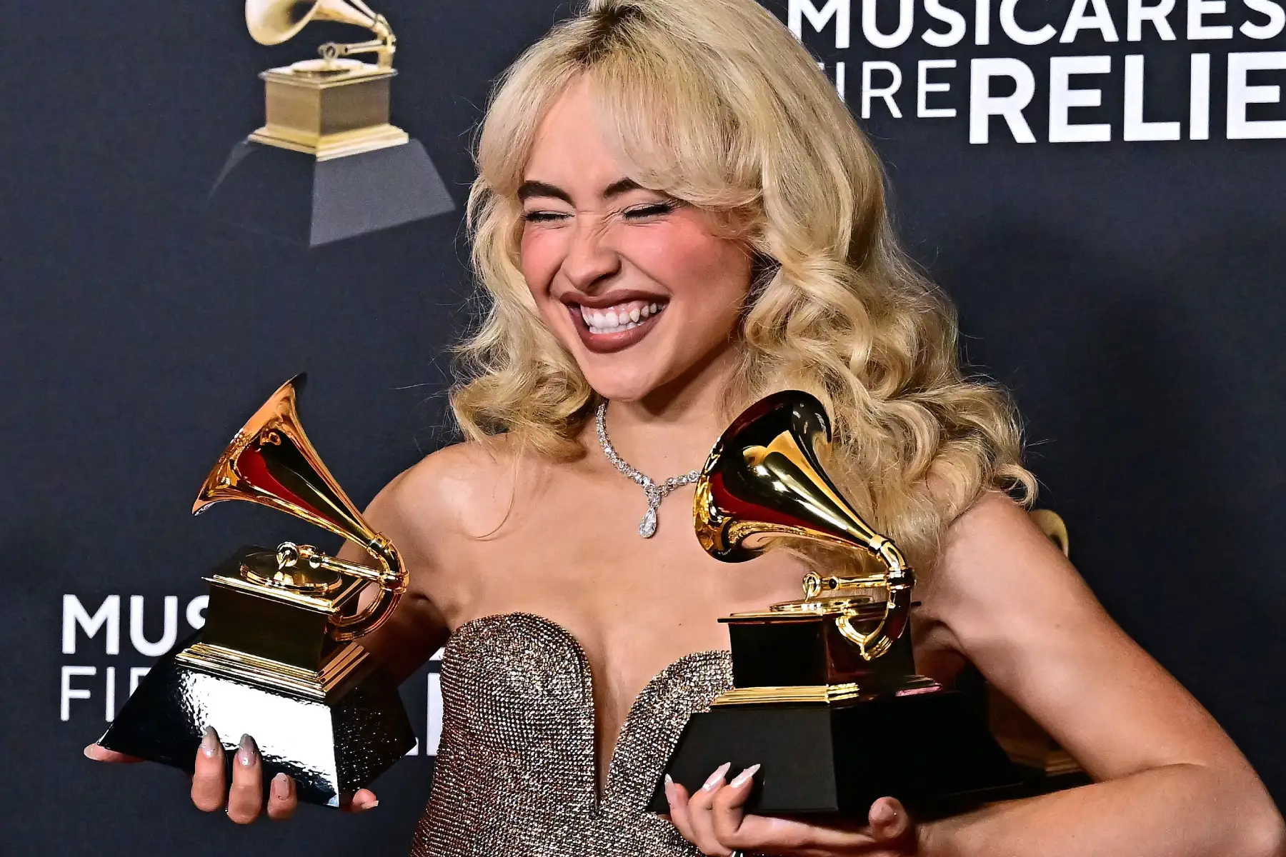 Sabrina Carpenter sosteniendo dos premios Grammy