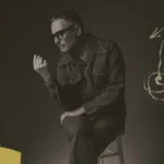 Jorge Drexler sentado en un taburete