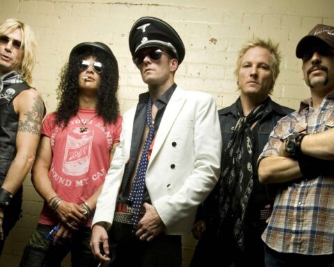 Velvet Revolver con Matt Sorum posando con fondo amarillo