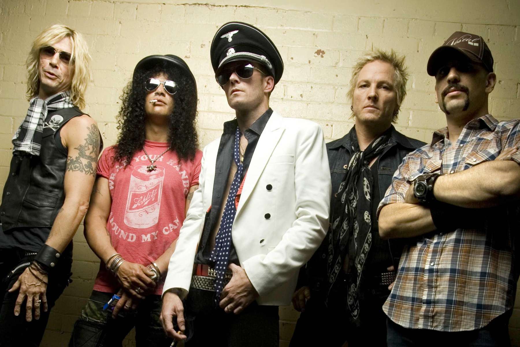 Velvet Revolver con Matt Sorum posando con fondo amarillo