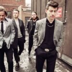 Arctic Monkeys caminando por una calle