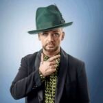 Boy George posando con fondo azul