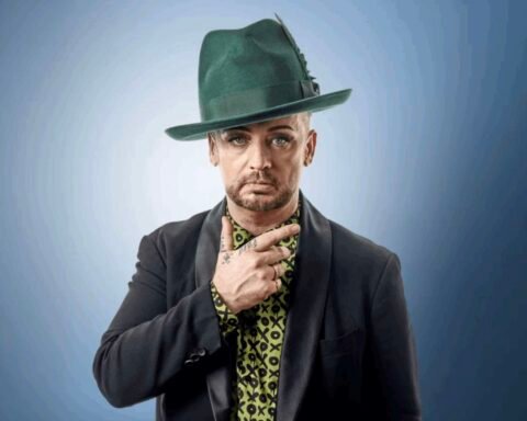 Boy George posando con fondo azul