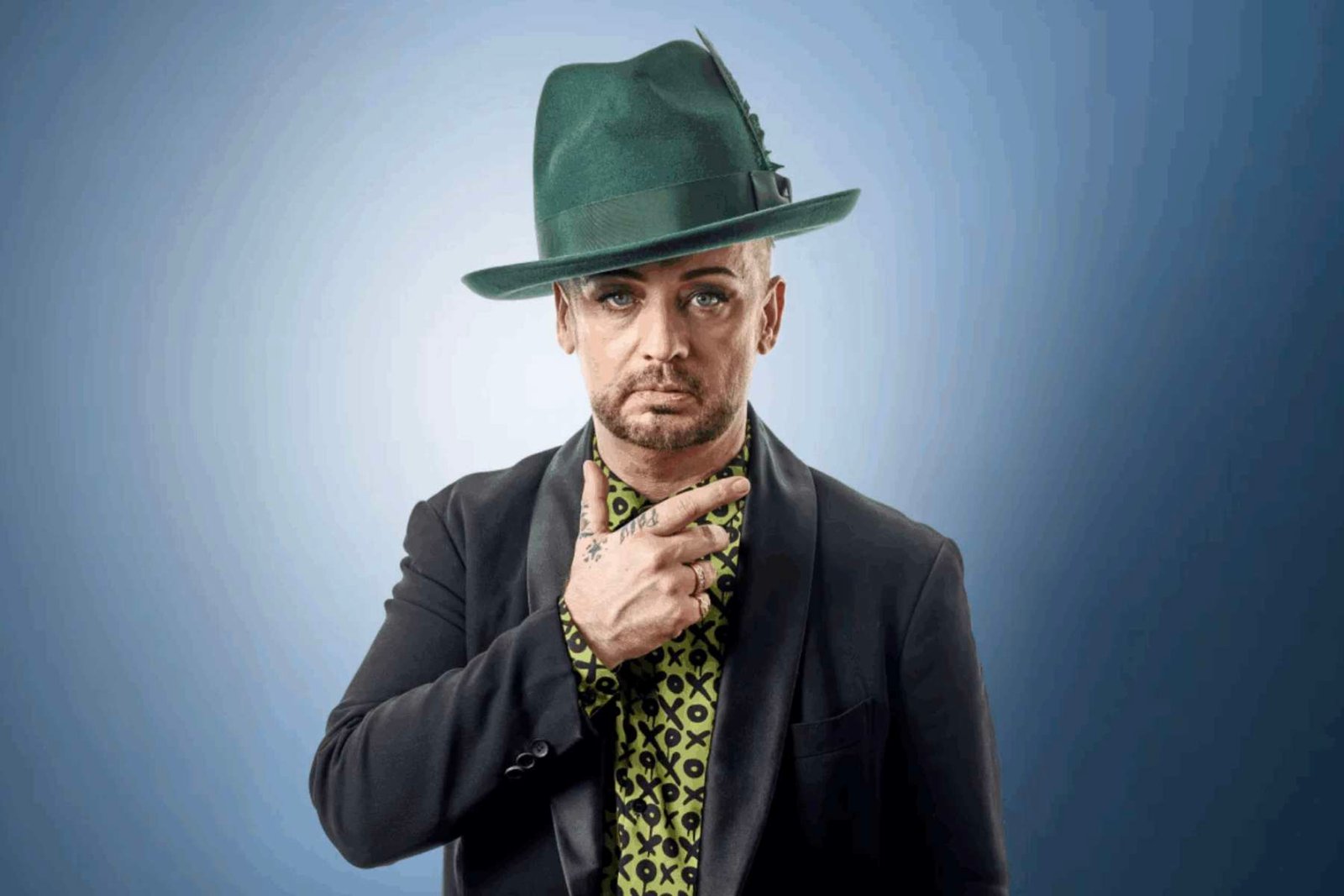 Boy George posando con fondo azul
