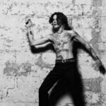 Jota Moore posando en una pared