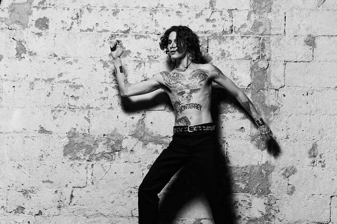 Jota Moore posando en una pared