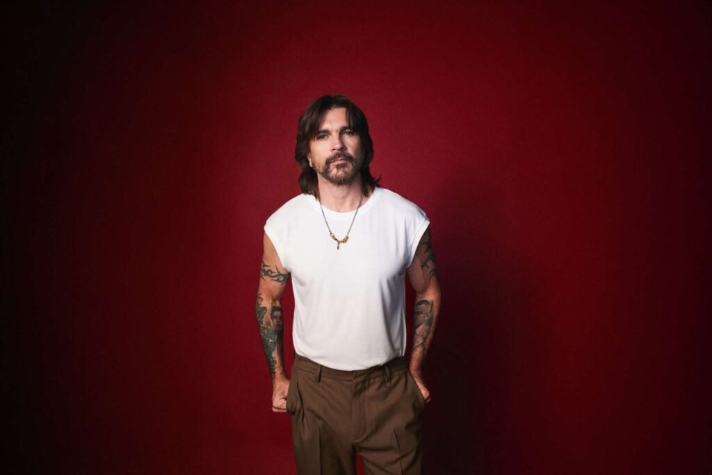 Juanes con polo blanco en fondo rojo