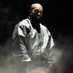 Kanye West con un traje gris en escenario