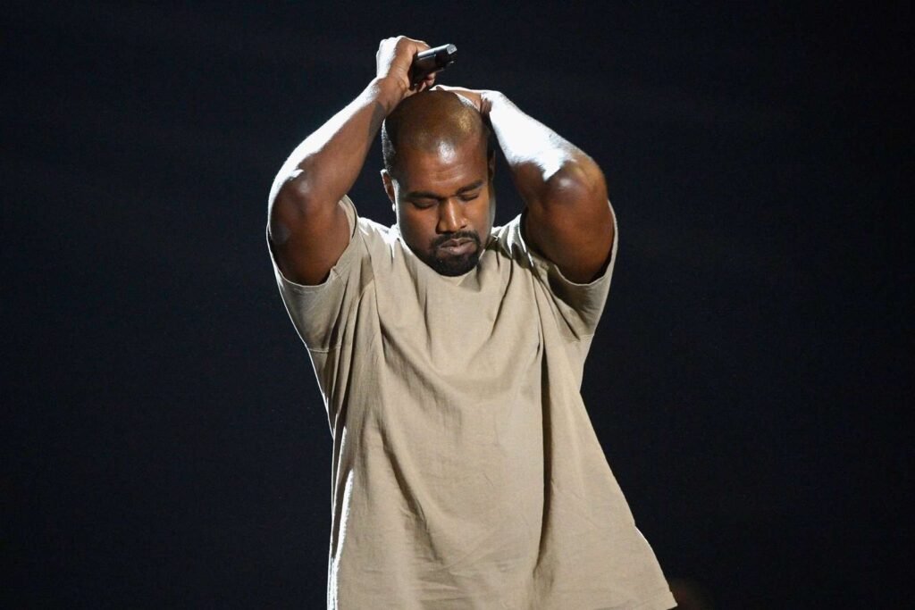 Kanye West con un polo crema en escenario