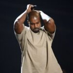 Kanye West con un polo crema en escenario