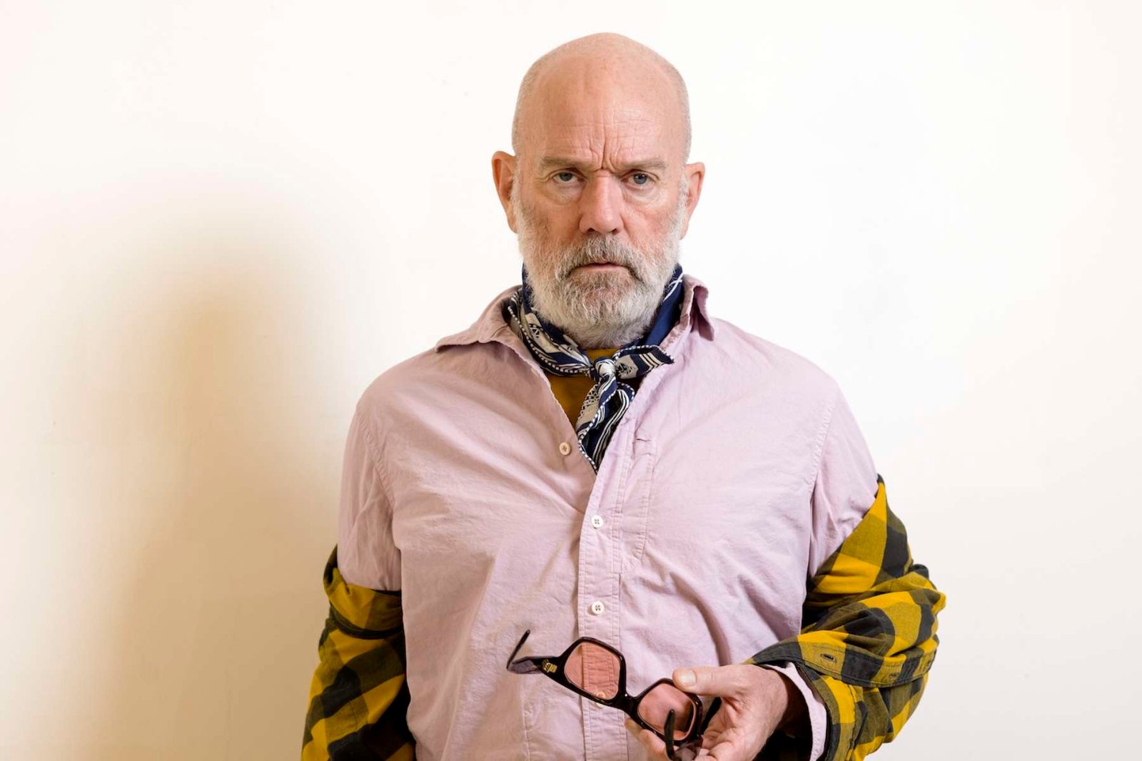 Michael Stipe posando con una pared