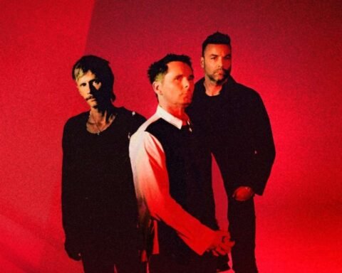 Muse posando con un fondo rojo