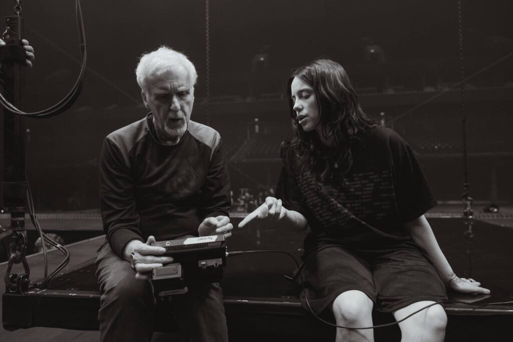 Billie Eilish sentada al lado de James Cameron