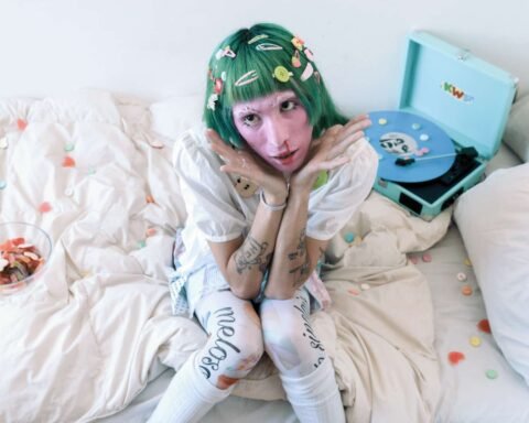 Lolito Sinclair en una cama con un tocadiscos