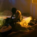 SobresDylan en una cama con su guitarra