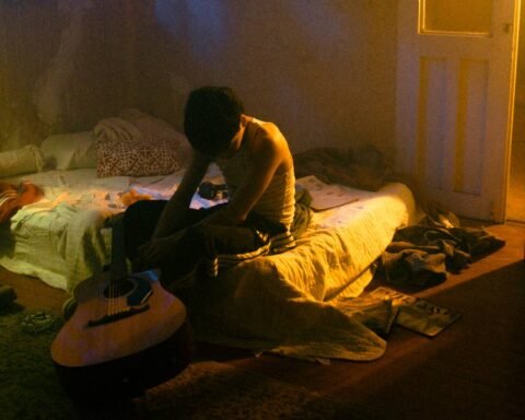 SobresDylan en una cama con su guitarra