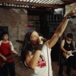 A.CHAL sosteniendo un micrófono