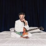 Fito Páez en una cama con su guitarra