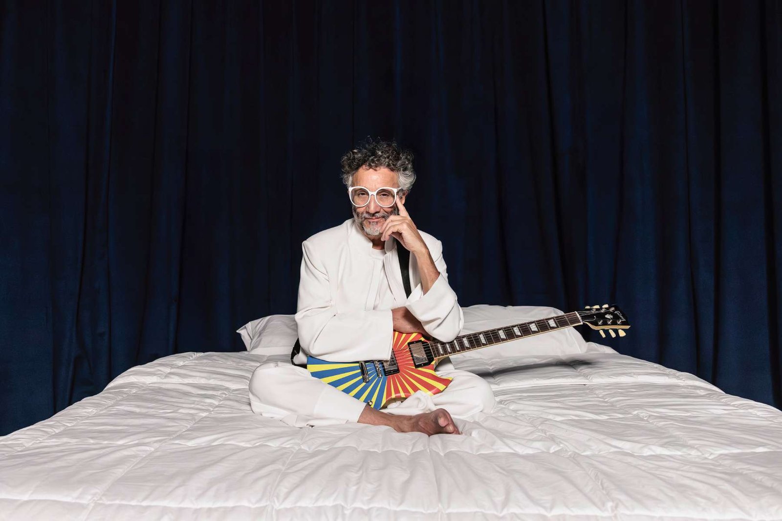 Fito Páez en una cama con su guitarra