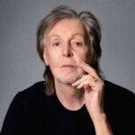Paul McCartney posando con fondo gris