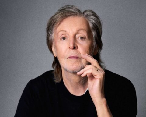Paul McCartney posando con fondo gris