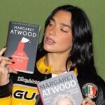 Dua Lipa sosteniendo dos libros