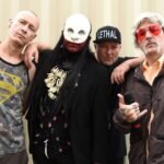 Limp Bizkit posando con fondo crema