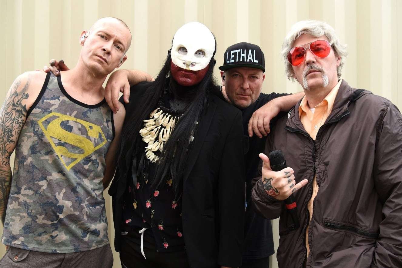 Limp Bizkit posando con fondo crema