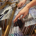 Personas observan discos compactos en una tienda de música, Nueva York, 2004