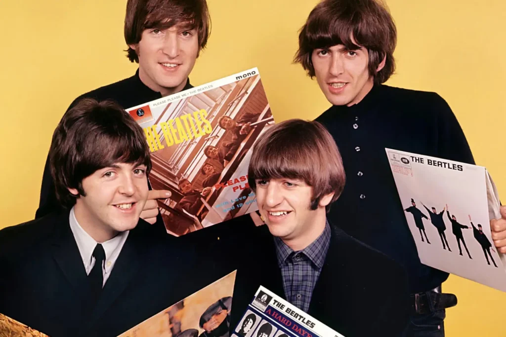 The Beatles sosteniendo sus álbumes