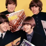 The Beatles sosteniendo sus álbumes
