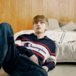V de BTS en una cama