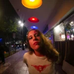 Cristina Palacios de noche en una calle iluminada con luces de neón