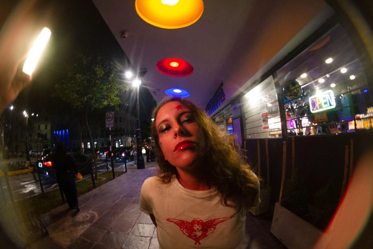 Cristina Palacios de noche en una calle iluminada con luces de neón