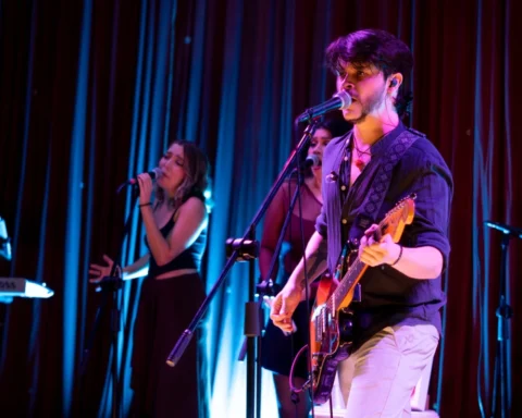 DEBRA en concierto, con un guitarrista y cantante frente al micrófono