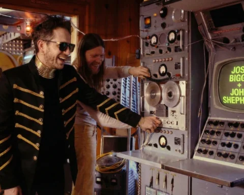 José Biggs y John Shepherd frente a una consola de transmisión, en una imagen del universo visual de “Algoritmos”