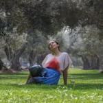 La Lá recostada sobre el pasto en un olivar