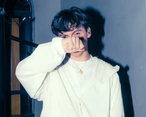 Sobresdylan con traje blanco tapándose la cara