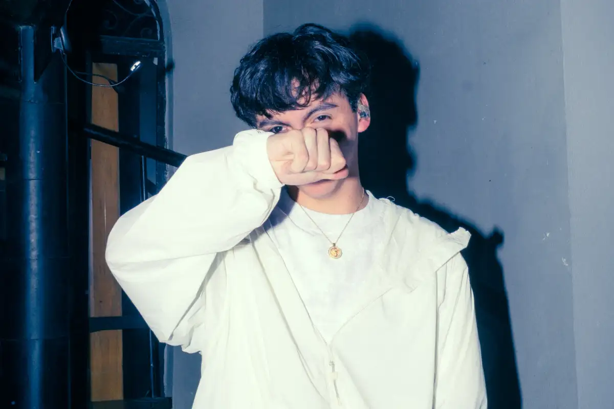 Sobresdylan con traje blanco tapándose la cara
