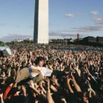 Un asistente sobre la multitud frente al Monumento a Washington durante el concierto benéfico de Turnstile