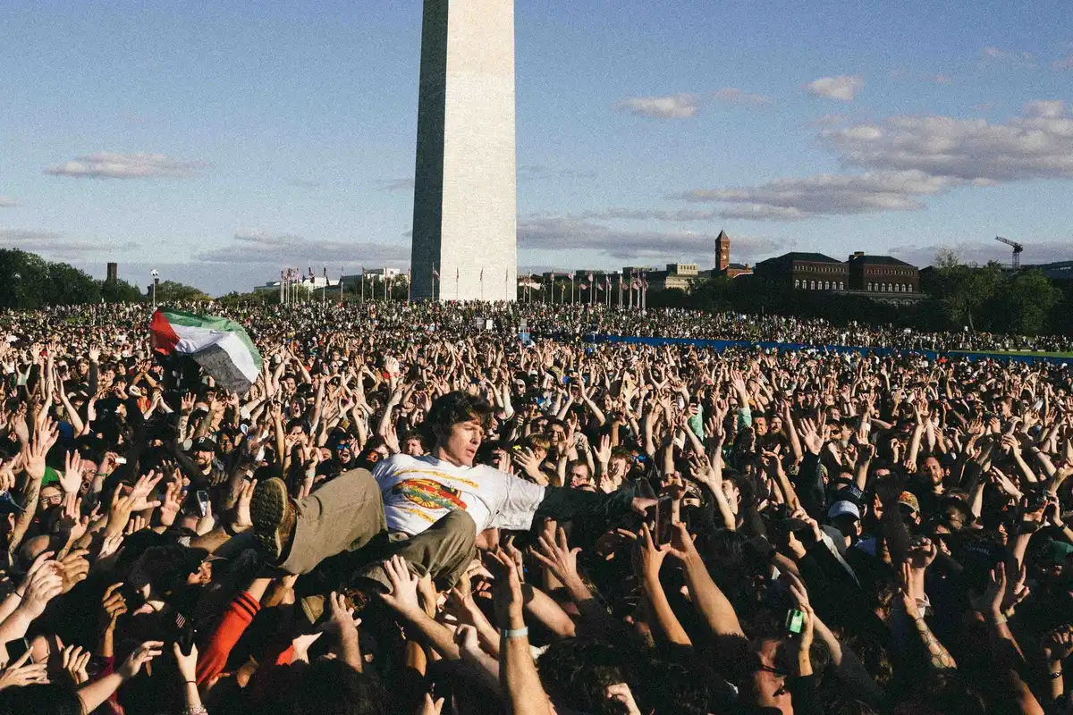 Un asistente sobre la multitud frente al Monumento a Washington durante el concierto benéfico de Turnstile